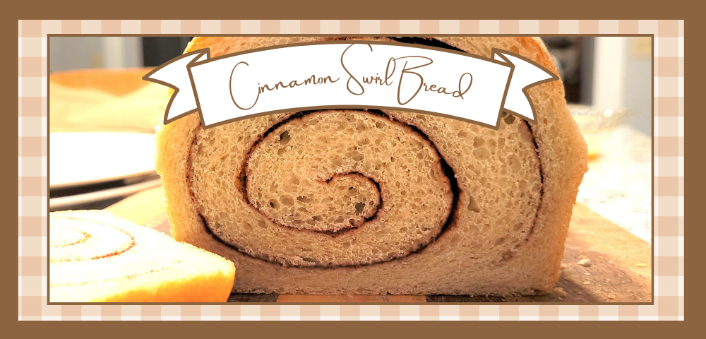Cut loaf of cinnamon swirl bread on a wooden cutting board