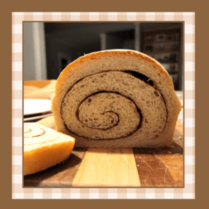 Cut loaf of cinnamon swirl bread on a wooden cutting board