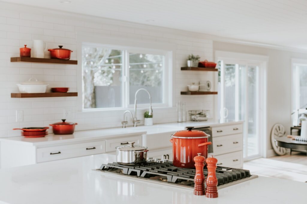 Clean white kitchen with red accents