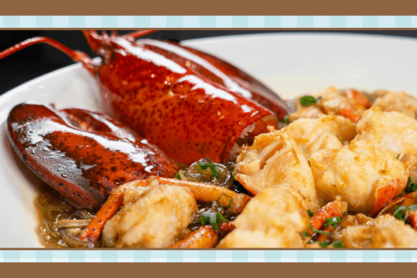 Lobster tail and fried seafood on a white plate with a light sauce and herbs presented as a dish