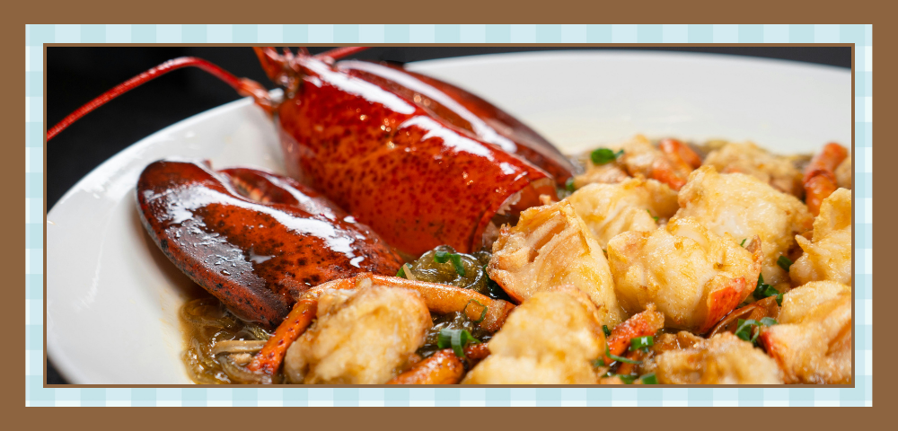 Lobster tail and fried seafood on a white plate with a light sauce and herbs, presented as a dish.