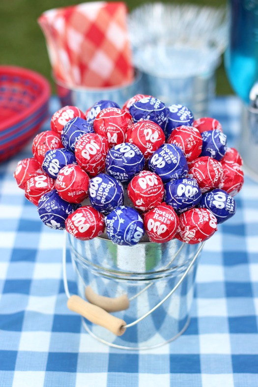 Red and blue wrapped Tootsie Pops arranged in a metal pail