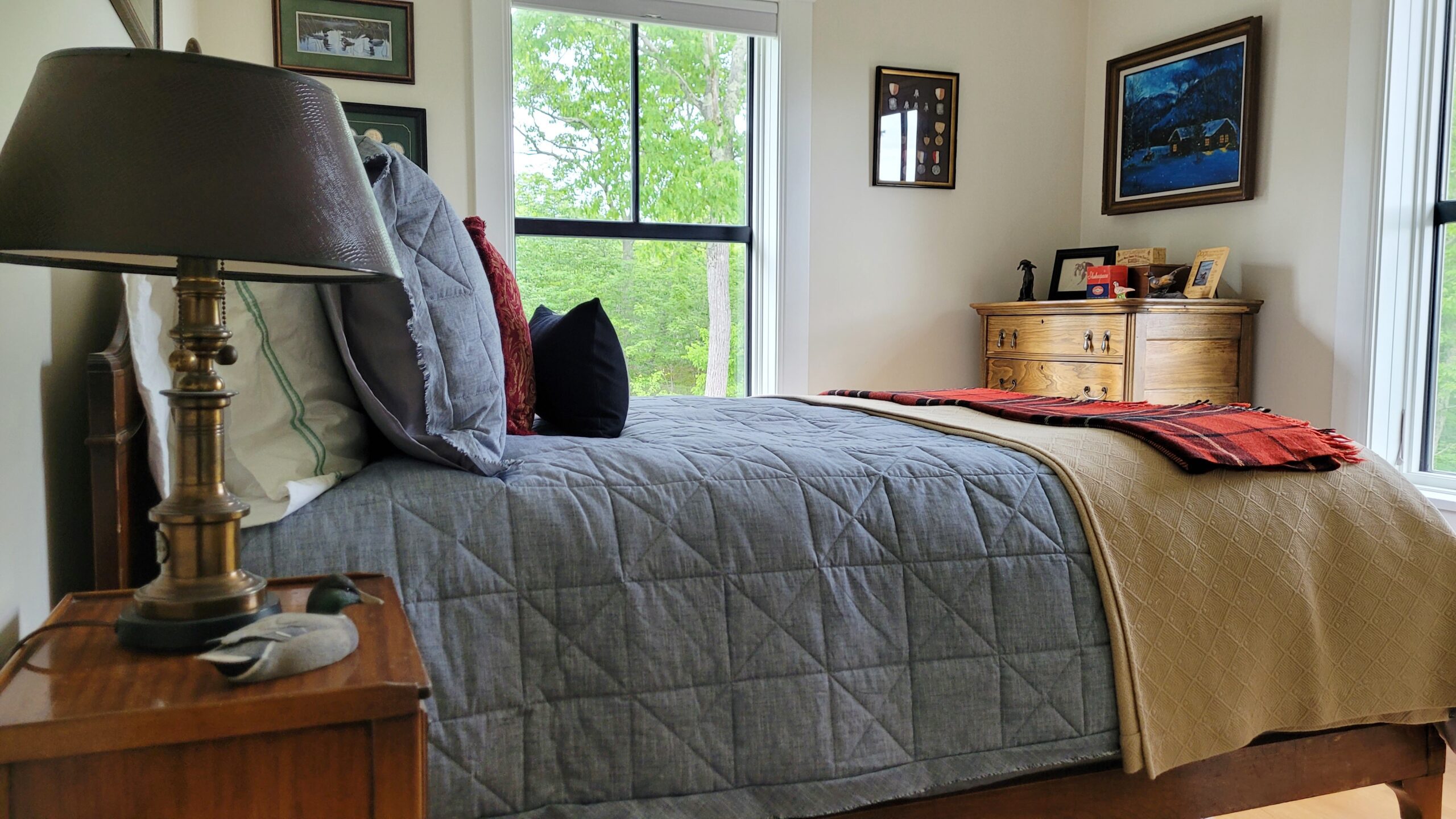 View of the guest room from an angle showing the nightstand, bed, and dresser.