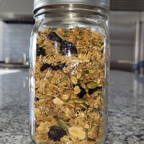 Jar of granola on a granite counter.