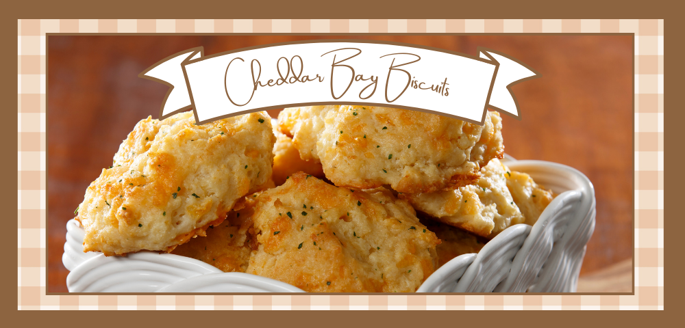 White ceramic basket holding a batch of Cheddar Bay Biscuits