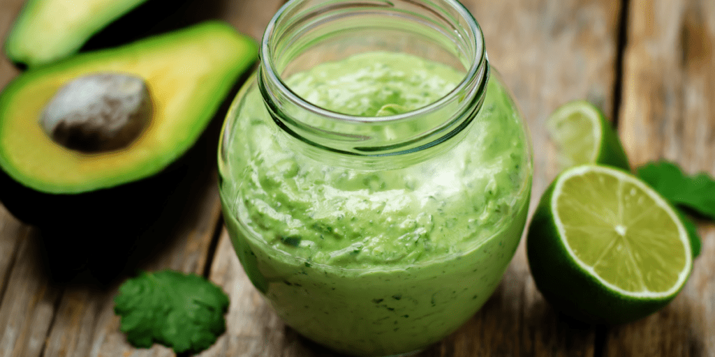 Jar of cilantro lime dressing on a wooden table