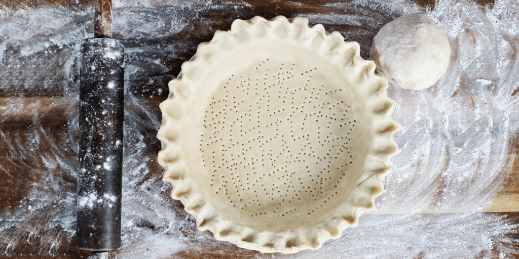 Single crust pie dough in a pie plate on a floured board