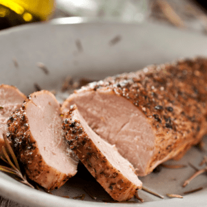 Roasted pork tenderloin, sliced on a white plate