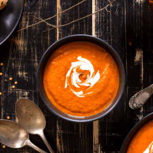 Bowl of roasted tomato soup with a splash of cream