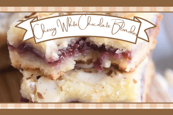 Two cherry filled white chocolate blondies stacked one on the other