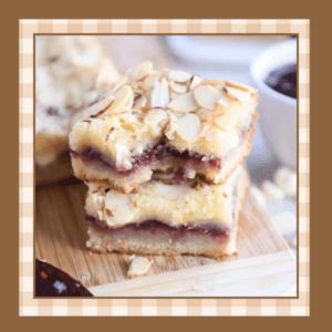 Two cherry filled white chocolate blondies stacked one on the other