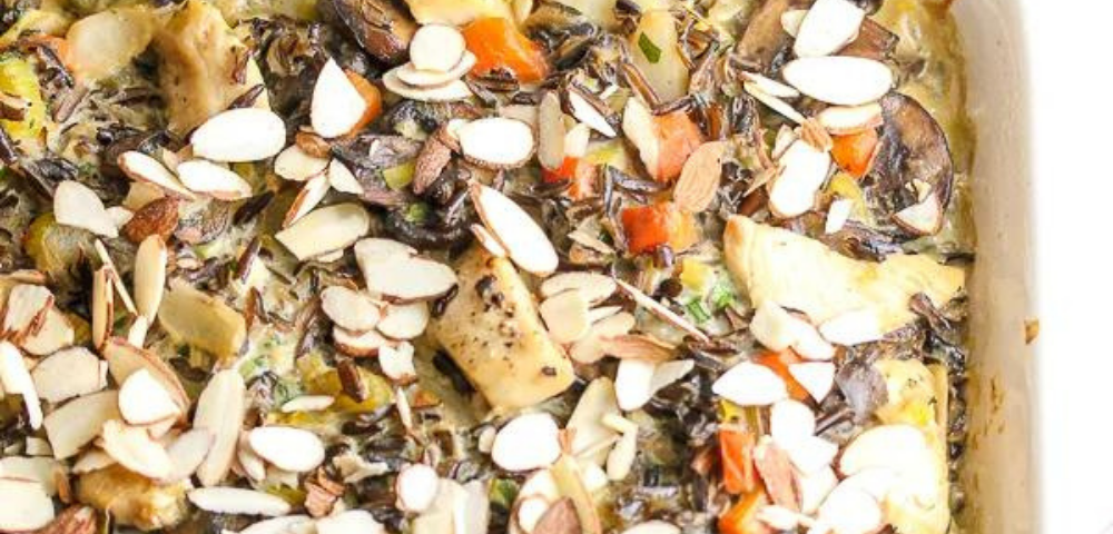Closeup of a dish of chicken wild rice casserole topped with sliced almonds.