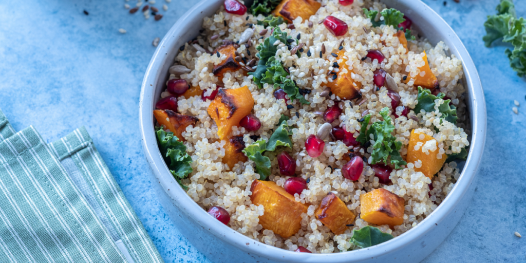 Bowl of quinoa butternut squash salad on a blue counter