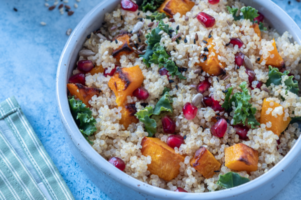 Bowl of quinoa butternut squash salad on a blue counter