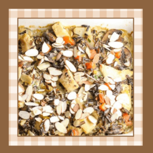 Wild-Rice-Casserole-Recipe | The Granite Acorn Closeup of a dish of chicken wild rice casserole topped with sliced almonds