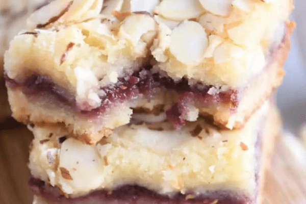 Two cherry filled white chocolate blondies stacked one on the other