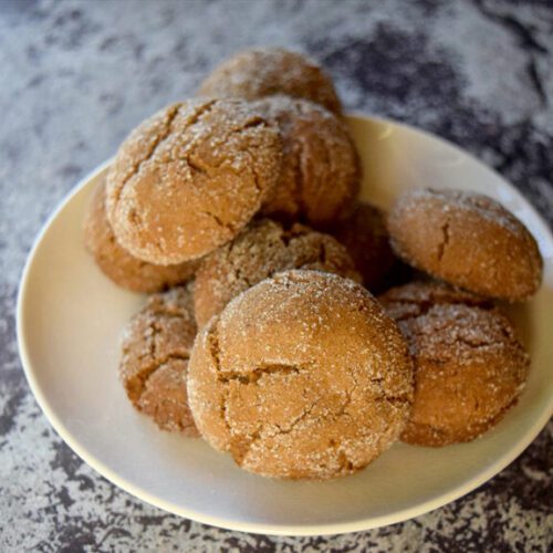 White plate with crinkle top cookies piled on top.