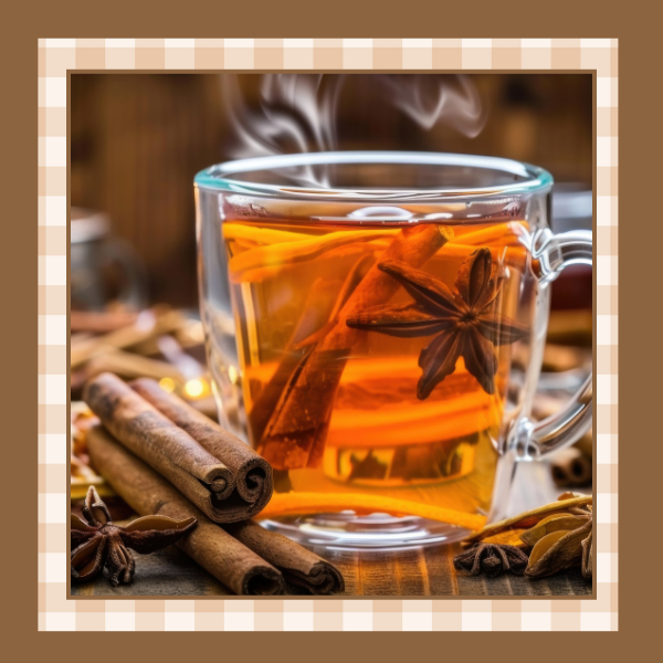 Clear mug of hot cider tea with cinnamon sticks and star anise