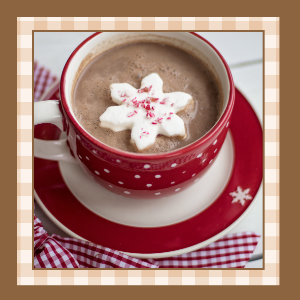 Hot cocoa in a red and white mug with a snowflake shaped marshmallow on top