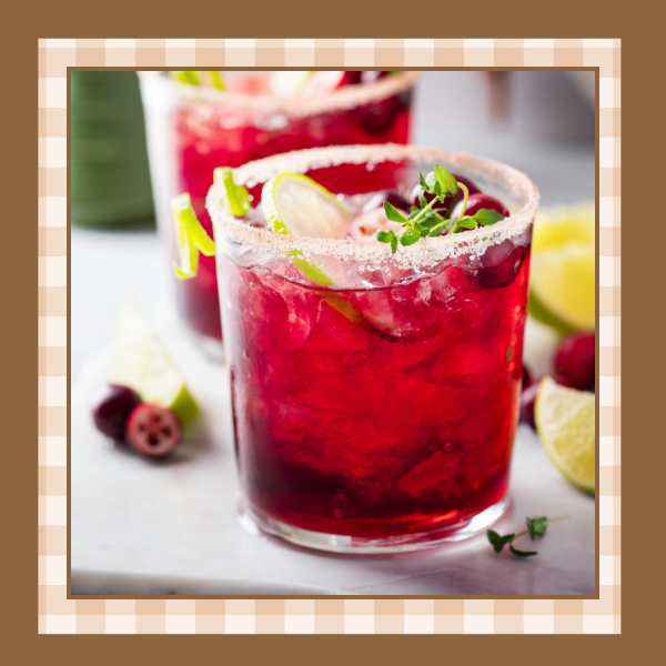 Glass of fizzy cranberry mocktail drink garnished with a lime and sugared rim