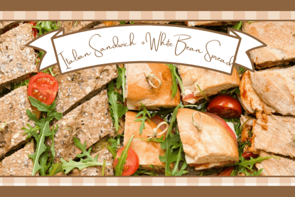Vegan italian sandwiches on italian bread cut into individual servings and garnished with greens and tomatoes