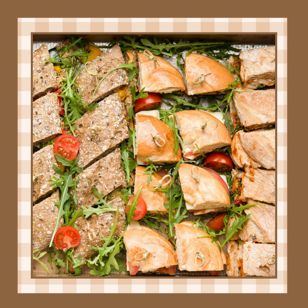 Italian-Sandwich-Recipe | The Granite Acorn Vegan italian sandwiches on italian bread cut into individual servings and garnished with greens and tomatoes