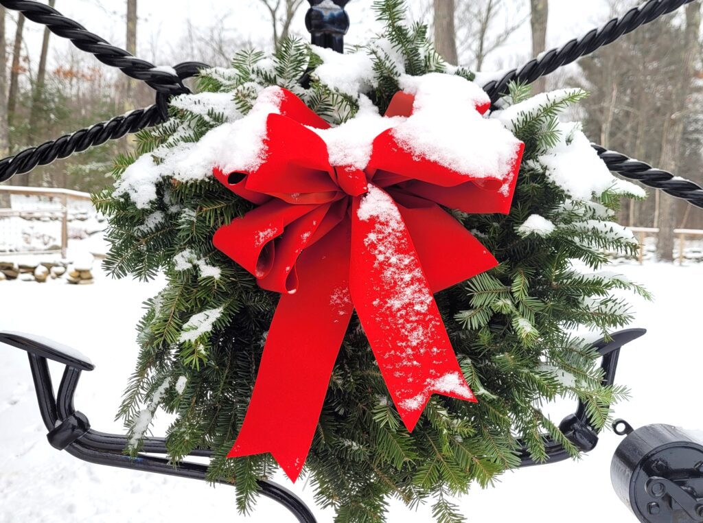 Balsam wreath with red bow dusted with snow