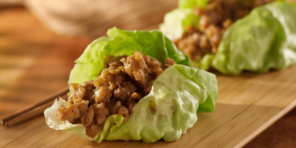 Asian lettuce wrap on a wooden serving board.