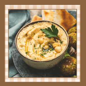 Closeup of gray bowl of hummus It's garnished with fresh parsley and crispy chickpeas