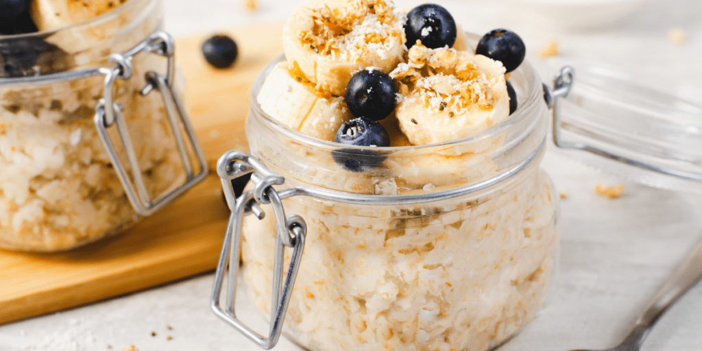 Jar of overnight oats topped with blueberries and bananas.