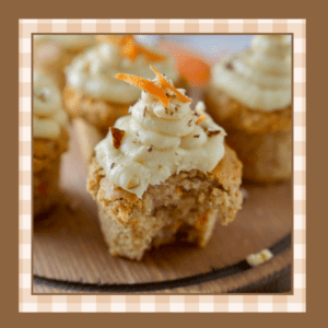 Closeup of a carrot cake cupcake with cream cheese frosting and a sprinkle of nuts A bite has been taken out of it