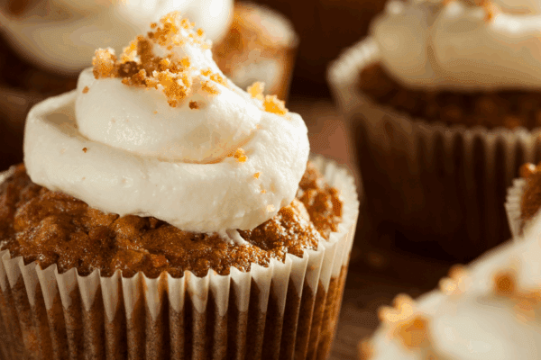 Carrot Cake Cupcakes-Banner | The Granite Acorn Closeup of a carrot cake cupcake with cream cheese frosting and a sprinkle of chopped nuts on top