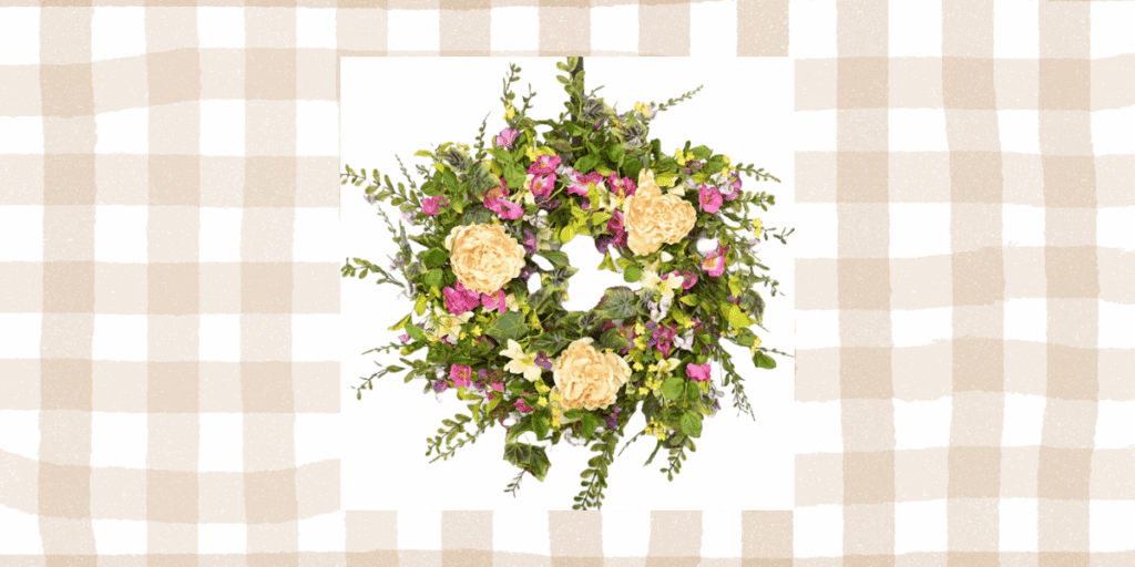 Spring wreath of peonies and small pink roses with eucalyptus and wildflowers. The image is on a tan gingham background.