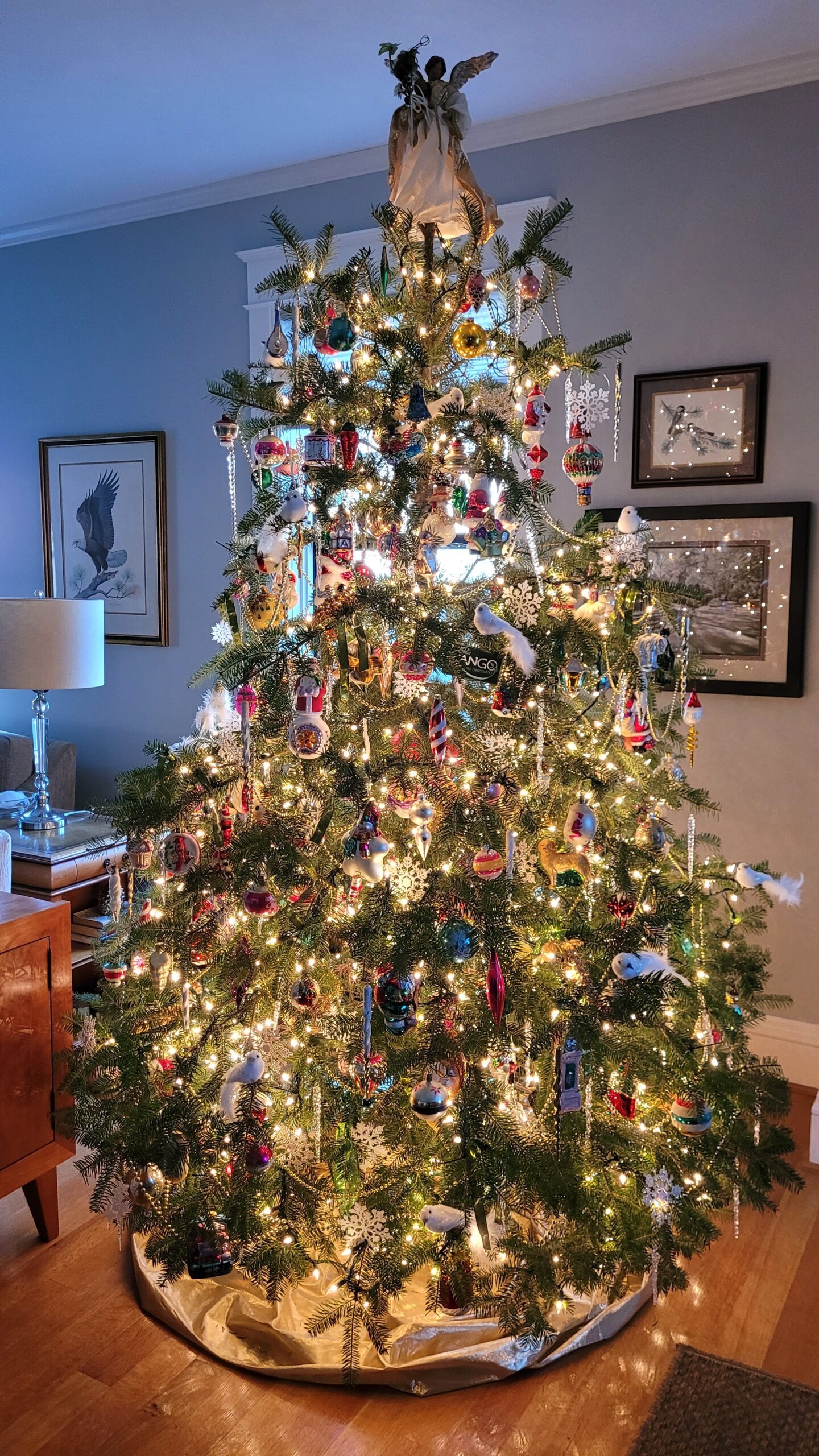 8 foot christmas tree with lots of vintage glass ornaments and an angel tree topper The tree is lit