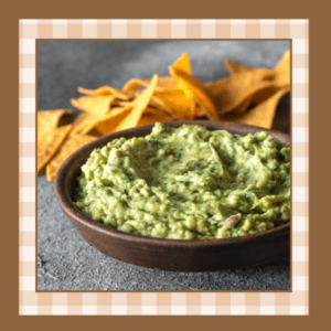 Bowl of guacamole with a pile of chips in the background