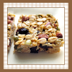 Oat based granola bar studded with almonds pepitas and dried cherries on a white plate